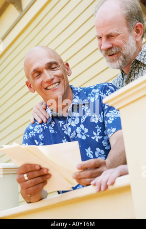 Gay couple reading mail Stock Photo