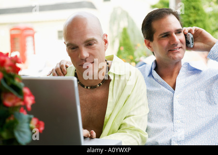 Middle-aged gay couple using technology Stock Photo