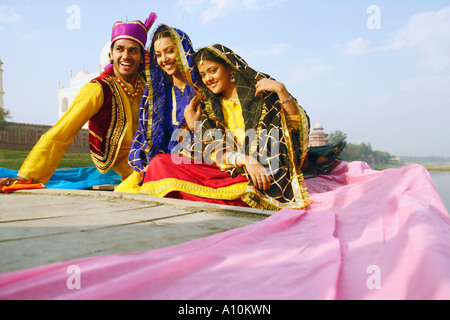Two young women and a young man sitting in a boat Stock Photo