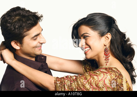 Side profile of a young woman embracing a young man Stock Photo