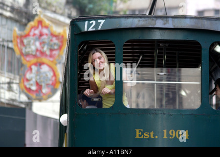 Leaning out of the tram in Wan Chai, Hong Kong Stock Photo