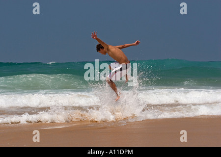 A skimboarder on Cordoama beach, in Algarve (Portugal).  Skimboarder sur la plage de Cordoama, en Algarve (Portugal). Stock Photo