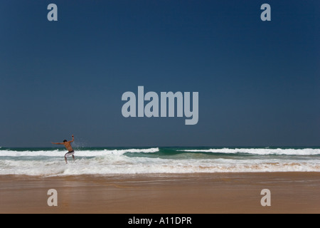 A skimboarder on Cordoama beach, in Algarve (Portugal).  Skimboarder sur la plage de Cordoama, en Algarve (Portugal). Stock Photo