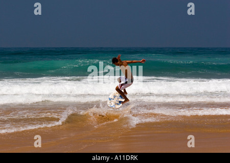 A skimboarder on Cordoama beach, in Algarve (Portugal).  Skimboarder sur la plage de Cordoama, en Algarve (Portugal). Stock Photo