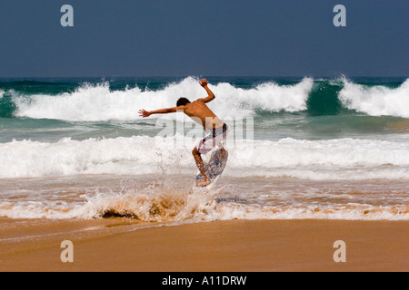 A skimboarder on Cordoama beach, in Algarve (Portugal).  Skimboarder sur la plage de Cordoama, en Algarve (Portugal). Stock Photo