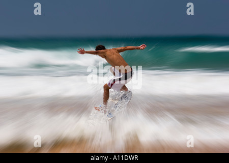 A skimboarder on Cordoama beach, in Algarve (Portugal).  Skimboarder sur la plage de Cordoama, en Algarve (Portugal). Stock Photo