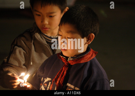 Two boys light firecrackers in a hutong near the Forbidden City, Beijing, China. Stock Photo