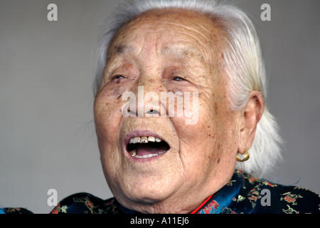 Old woman singing a traditional song to an audience in Temple of Heaven Park, Beijing China Stock Photo