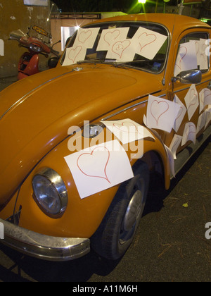 vw beetle car covered with love hearts by an admirer in rome, italy Stock Photo