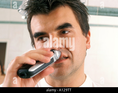 Man shaving in bathroom Stock Photo