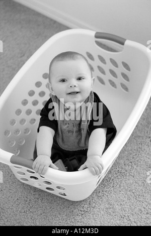 Baby in laundry basket Stock Photo