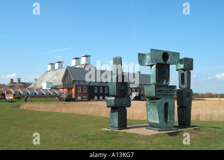 Snape Maltings Barbara Hepworth Family of Man sculpture in landscape converted theatre concert hall buildings beyond Suffolk East Anglia England UK Stock Photo