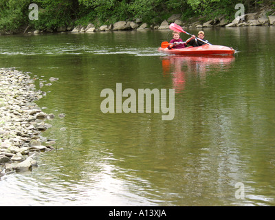 two teenagers on an idyllic canoe trip on calm river in Belgian Ardennes Stock Photo