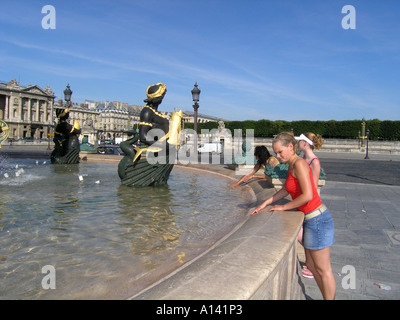 teenage tourists cooling off in pond at Place de la Concorde Paris France Stock Photo