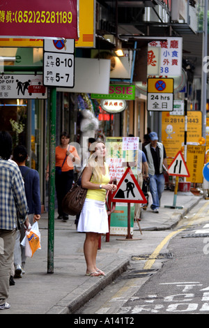 Young Woman Waiting for the bus in Hong Kong Stock Photo