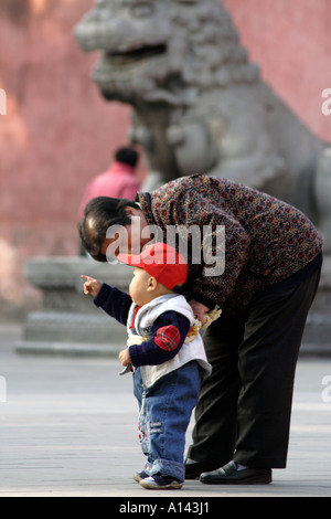 Grandson walks with the help of Grandmother in Jingshan Park, Beijing, China Stock Photo