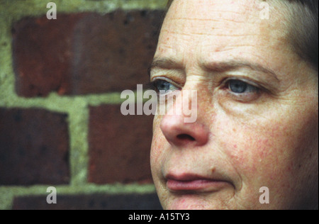 Close up of woman s face in front of brick wall Stock Photo