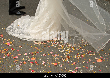 Horizontal close up of organic rose petal confetti on the ground after being thrown at the bride and groom at a summer wedding. Stock Photo