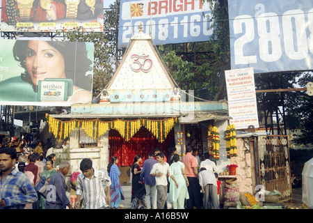Indian street Hindu temple with OM written surrounded by modern hoardings at Borivli Bombay Mumbai India Stock Photo