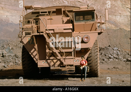 Big dump truck and female driver at Mt Newman iron ore mine Western Australia Stock Photo