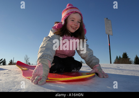 Young girl ready to go down a tobogganing hill Stock Photo