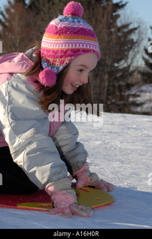 Young girl ready to go down a tobogganing hill Stock Photo