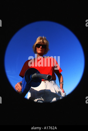 Abstract Attractive middle aged woman pumping gas seen from gas within tank Stock Photo