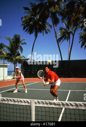 Attractive young couple playing tennis at Caribbean resort Stock Photo