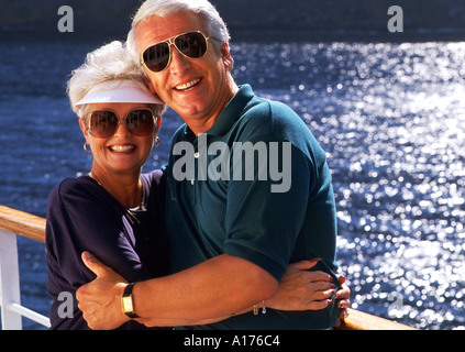 Retired senior couple wearing sunglasses enjoying the view on a cruise ship on deck Stock Photo