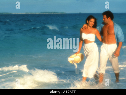 Attractive young couple walking on the beach Stock Photo