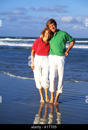 Attractive middle aged couple walking on the beach Stock Photo