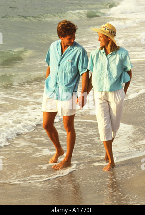 Attractive middle aged couple walking on the beach Stock Photo