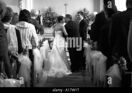 A bride being given away at the altar in a church Stock Photo