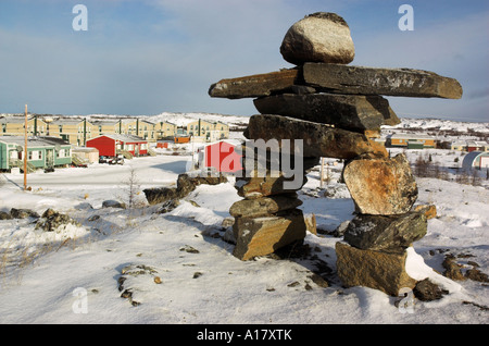 An inukshuk on a hill overlooking the arctic village of Kuujjuaq Stock Photo