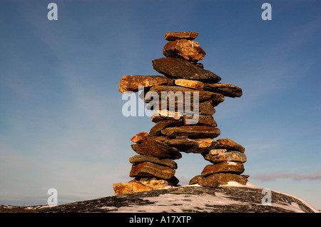 High clouds behind an inukshuk on a hill at Kuujjuaq Stock Photo