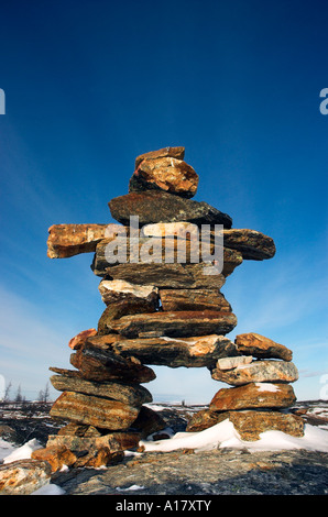 High clouds behind an inukshuk on a hill overlooking the arctic village of Kuujjuaq Stock Photo