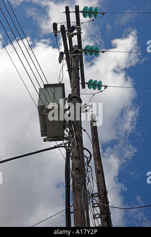 Three phase transformer and power lines with glass insulators on wooden support poles Village of Lefkes Island of Paros Greece Stock Photo