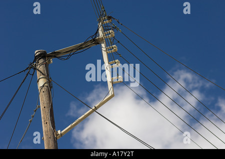 Power lines with ceramic insulators on wooden support poles and metal support bar Stock Photo