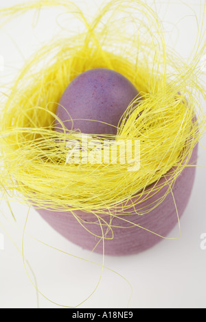 Purple Easter egg in yellow Easter Grass Stock Photo