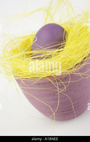 Purple Easter egg in yellow Easter Grass Stock Photo