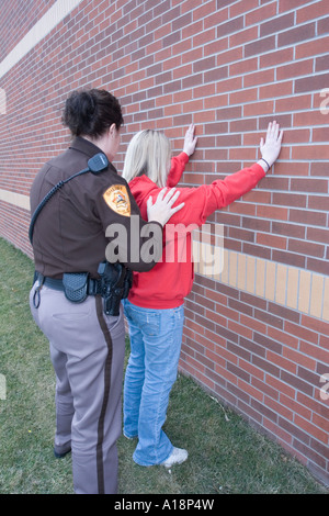 Young female being arrested by female deputy sheriff Saline County Sheriffs Office Nebraska Stock Photo