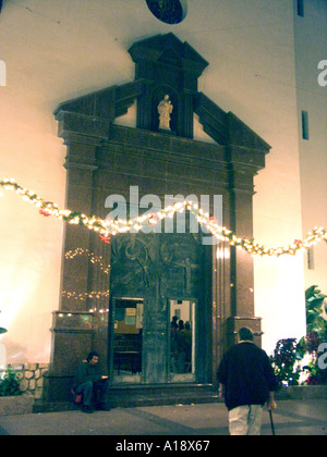 Homeless Beggar sits on the church steps on Christmas Eve Stock Photo