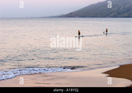 Surfers at Sunrise in Maui, Hawaii Stock Photo