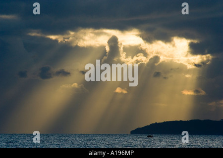 Rays of sun bursting through clouds over Poole Bay, Dorset, UK Stock Photo