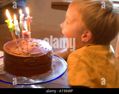 Five year old boy blowing out birthday candles. St Paul Minnesota MN USA Stock Photo