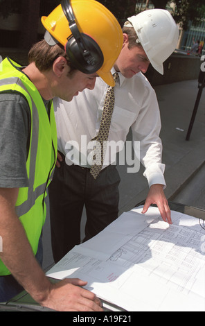 construction worker with engineer looking at blueprints Stock Photo