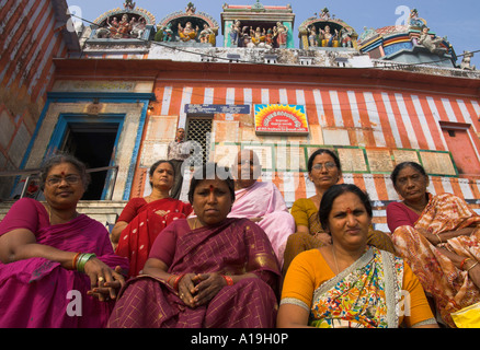 India Uttar Pradesh Ganges valley Varanassi group of women pilgrims sitting on the steps of Kedar ghat with temple in bkgd Stock Photo