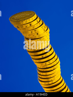 Column of gold pound coins on a blue background Stock Photo