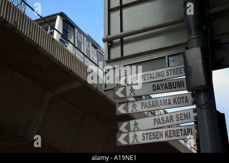 overhead train and signboard showing direction to popular places in city centre of kuala lumpur malaysia Stock Photo