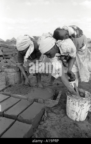 B/W of refugee returnees who fled to Zimbabwe during the civil war making bricks to rebuild their homes in a peaceful, settled Mozambique Stock Photo